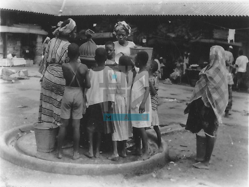 Деца и жене стоје око чесме на пијаци (VZP.N.220-08)