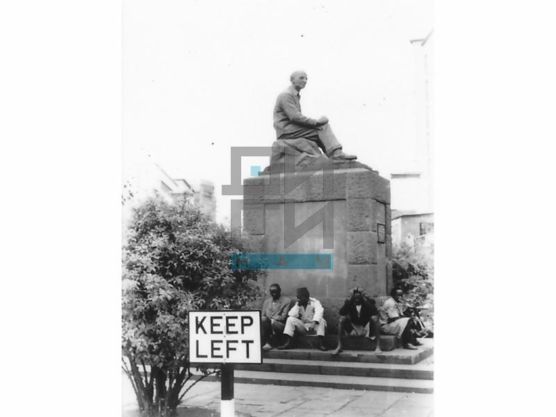 Ljudi sede ispred spomenika u Najrobiju (VZP.N.191-13)